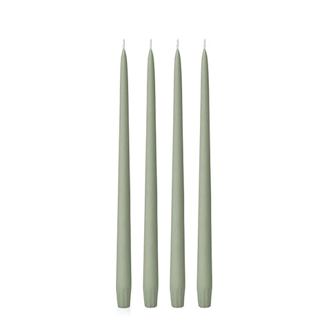 Four 25cm green candles on a white background
