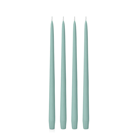 Four sage green 25cm candles on a white background