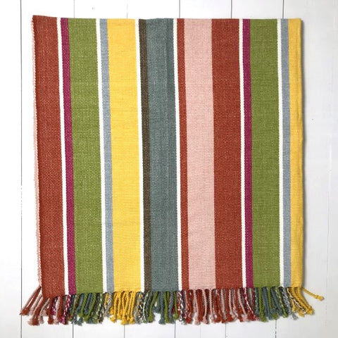 Striped rug with multicolor pattern on a white wooden floor