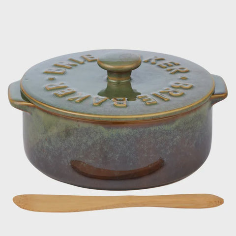 Ceramic dish with wooden spoon on a white background