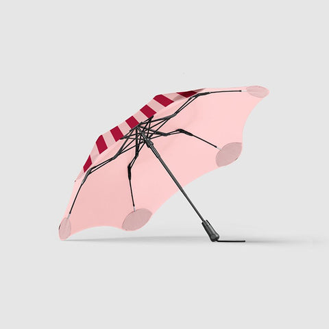 Red and white striped umbrella on a light gray background