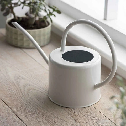 White watering can on a white background