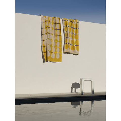 Yellow towel with white circle pattern on a white background