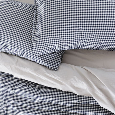 Navy and white checkered pillow on a white background