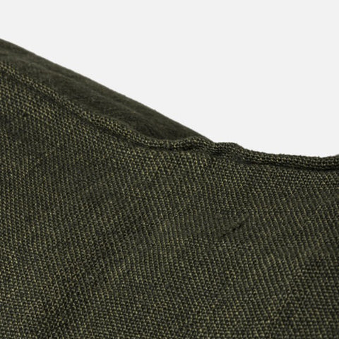 Dark green cushion on a light grey background
