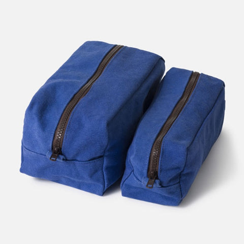 Blue toiletry bag on a bathroom counter with a sink and faucet in the background