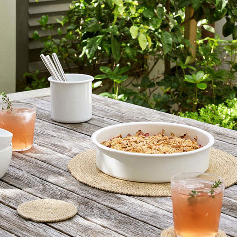 Round woven citta placemat on a light gray background