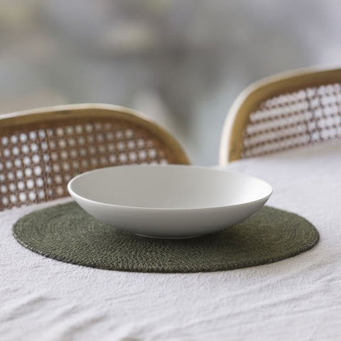 Round olive green woven placemat on a light gray background