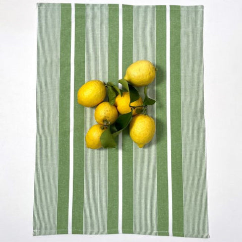 Fruit plate with bananas, oranges, and limes on a red and white striped tablecloth.