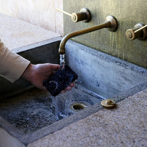 DESIGNSTUFF Compressed Cellulose Sponge in black on a kitchen sink