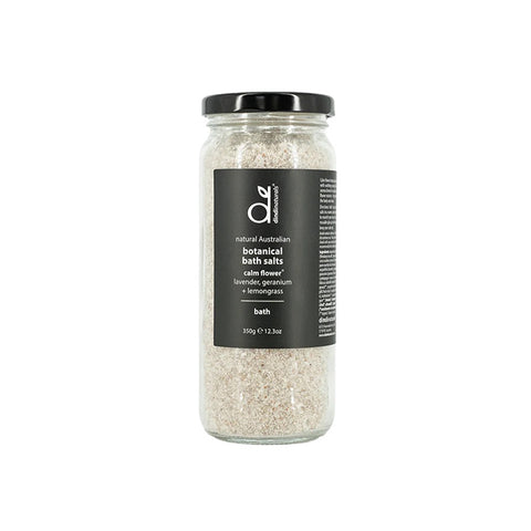 Jar of botanical bath salts with a label on a wooden board with herbs, on a light background