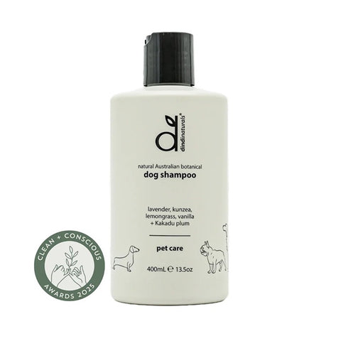 Dog shampoo bottle on a wooden platform with eucalyptus leaves against a gray background