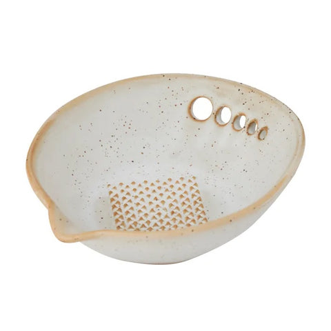 Speckled ceramic dish with a textured pattern for grating on a white background