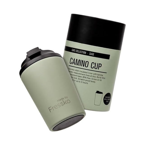 Green coffee cup with black lid and packaging on a white background