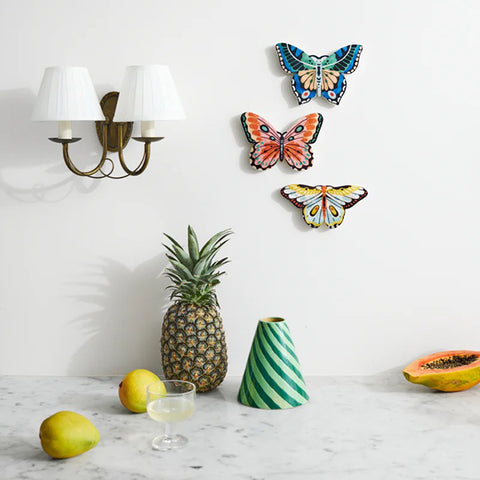 Butterfly-shaped wall art with pink and orange design on a white background