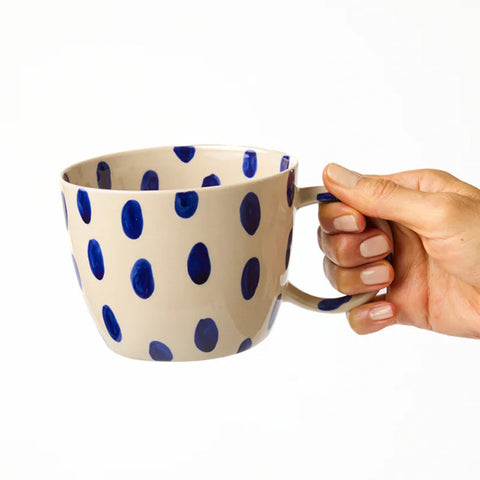 Beige mug with blue polka dots on a white background