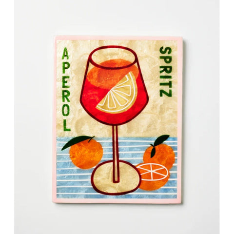 Aperol Spritz bottle with a glass of spritz and a decorative card on a textured white background