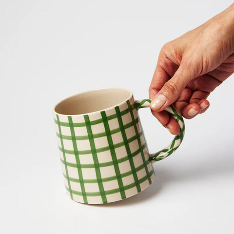 Mug with green and beige checkered pattern on a white background