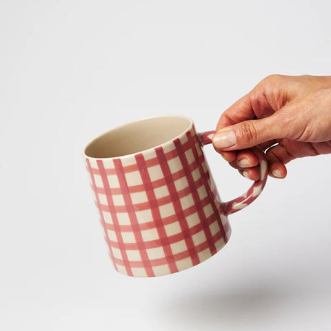 Pink and white checkered mug on a white background