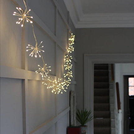 Lumina Of London Starburst Chain Lights in Silver hang on a wall inside a hallway