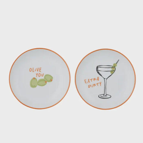 Two round plates with humorous designs and text on a white background