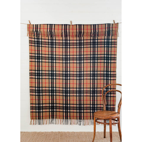 The Grampian Goods Co Tartan Blanket in Camel on a white sofa